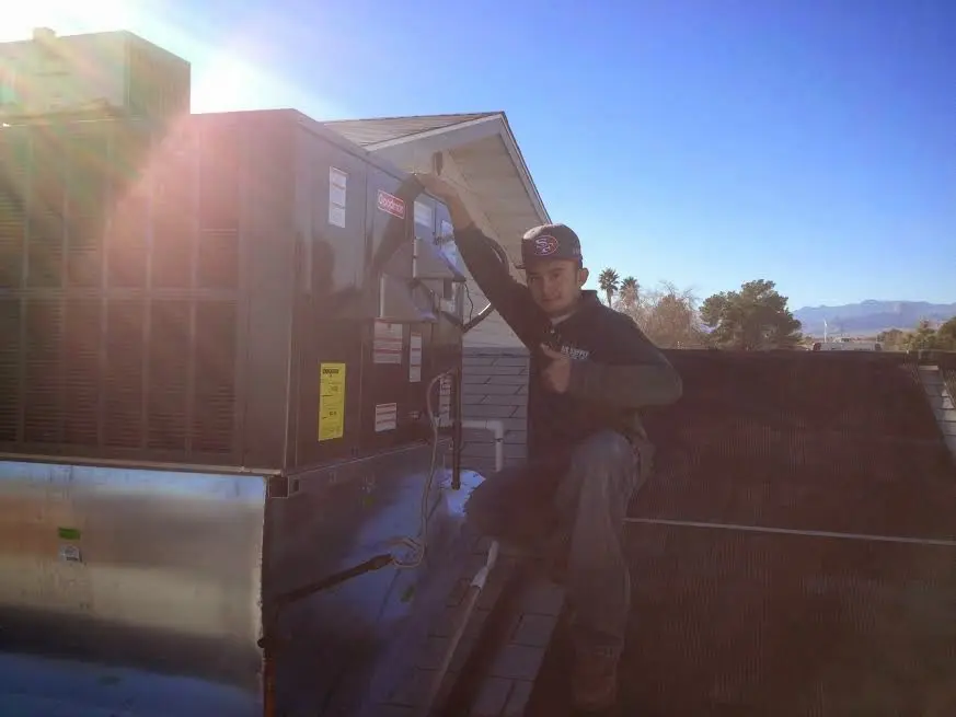 HVAC technician performing HVAC Inspection on a rooftop unit in Gilberts